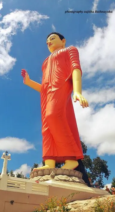 a large statue of a man in a red dress capture with drone 360°