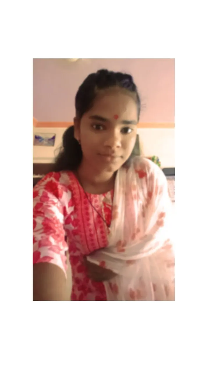 a young girl in a red and white sari and beautiful looking 