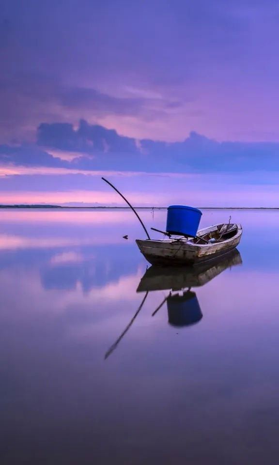 a small boat floating on top of a large body of water