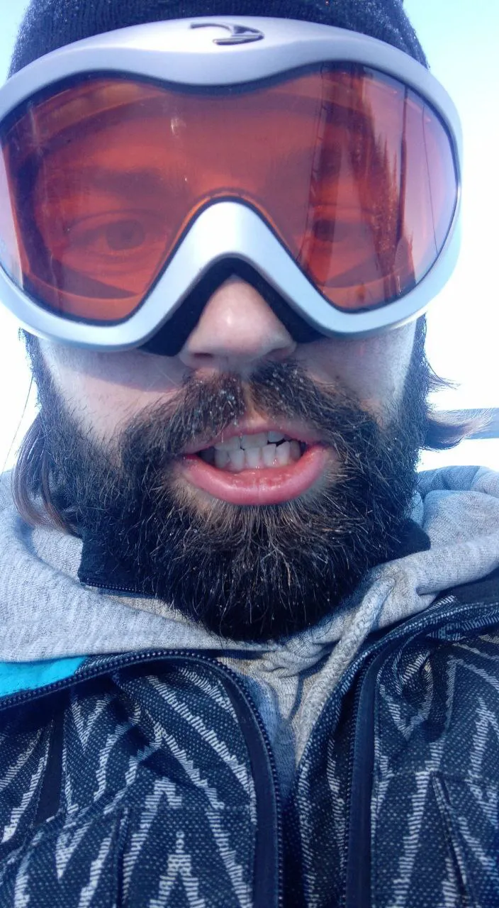 a man with a beard wearing ski goggles