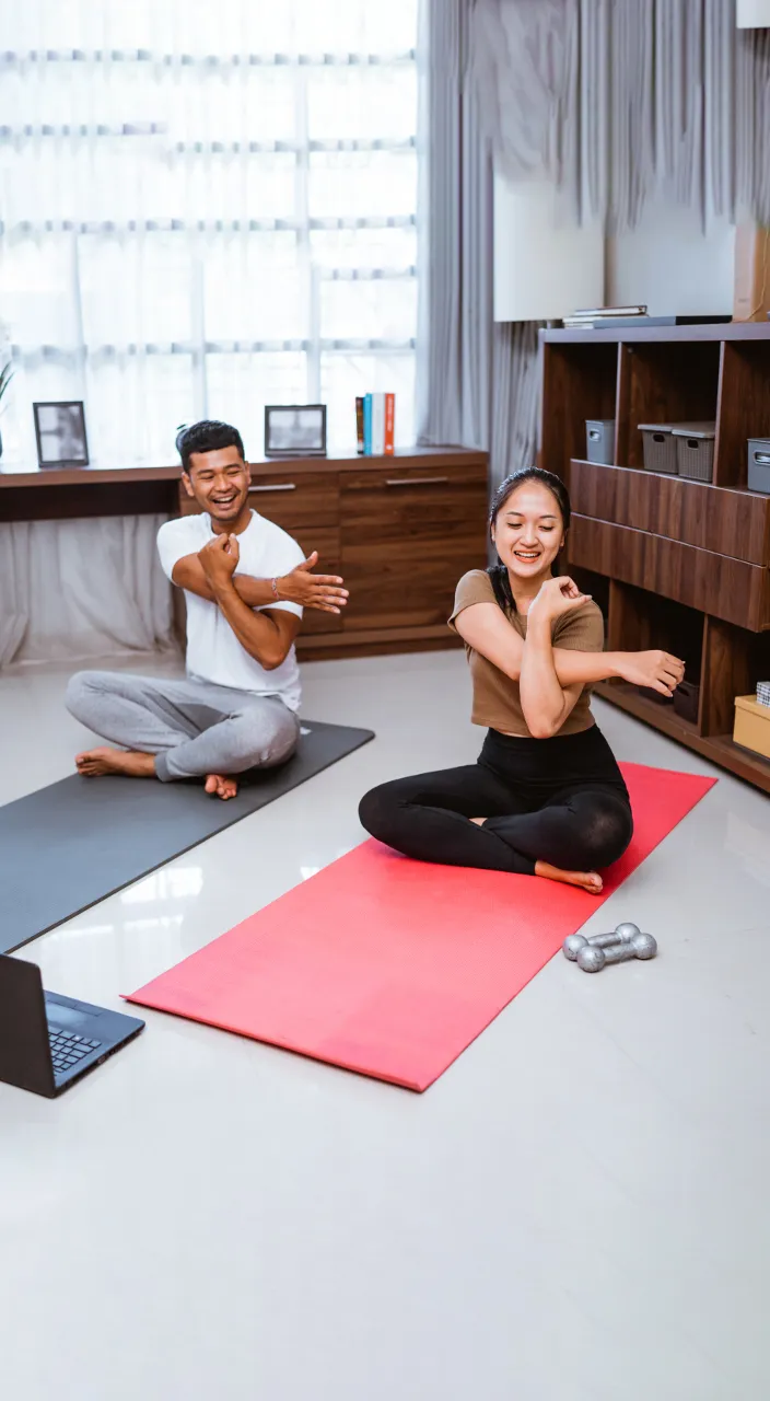 a man and a woman doing yoga in a living room