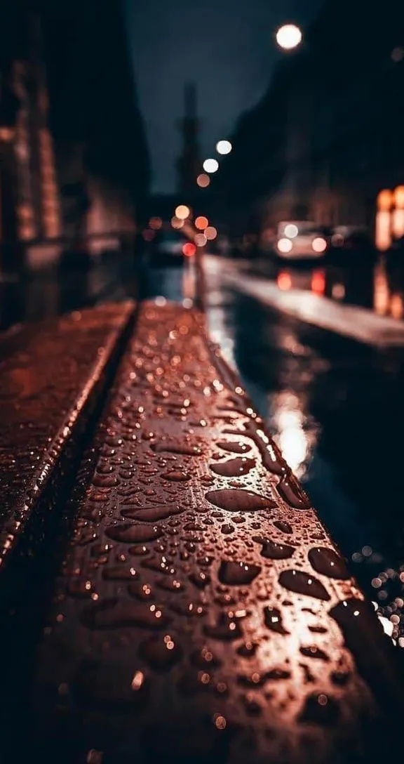 rain drops on a wet sidewalk at night