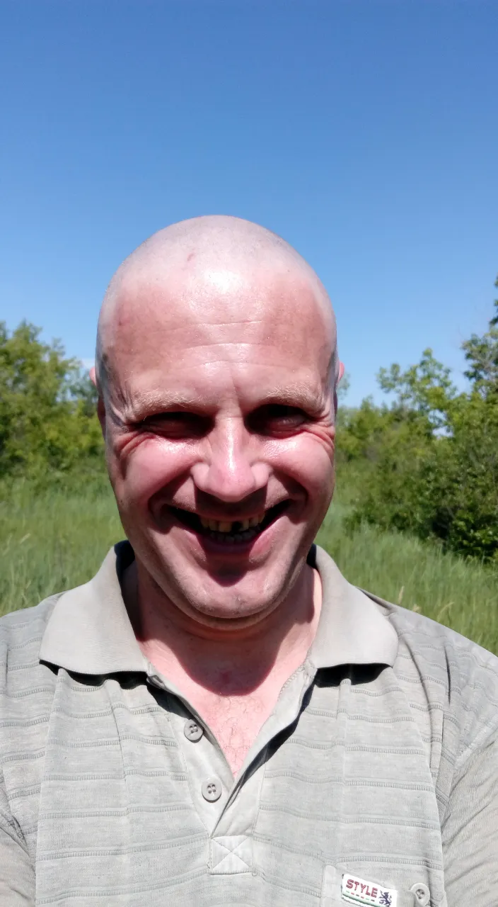 a man with a bald head is smiling for the camera