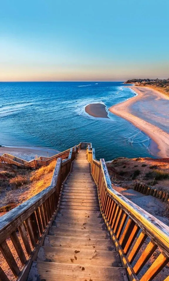 a wooden staircase going down to the beach