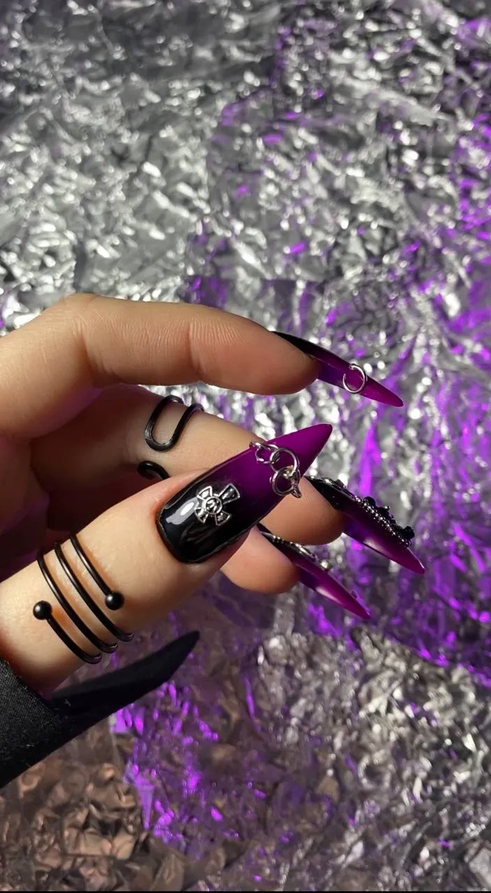 a woman's hand holding a purple and black manicure