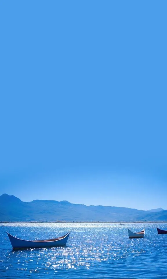 a group of boats floating on top of a large body of water