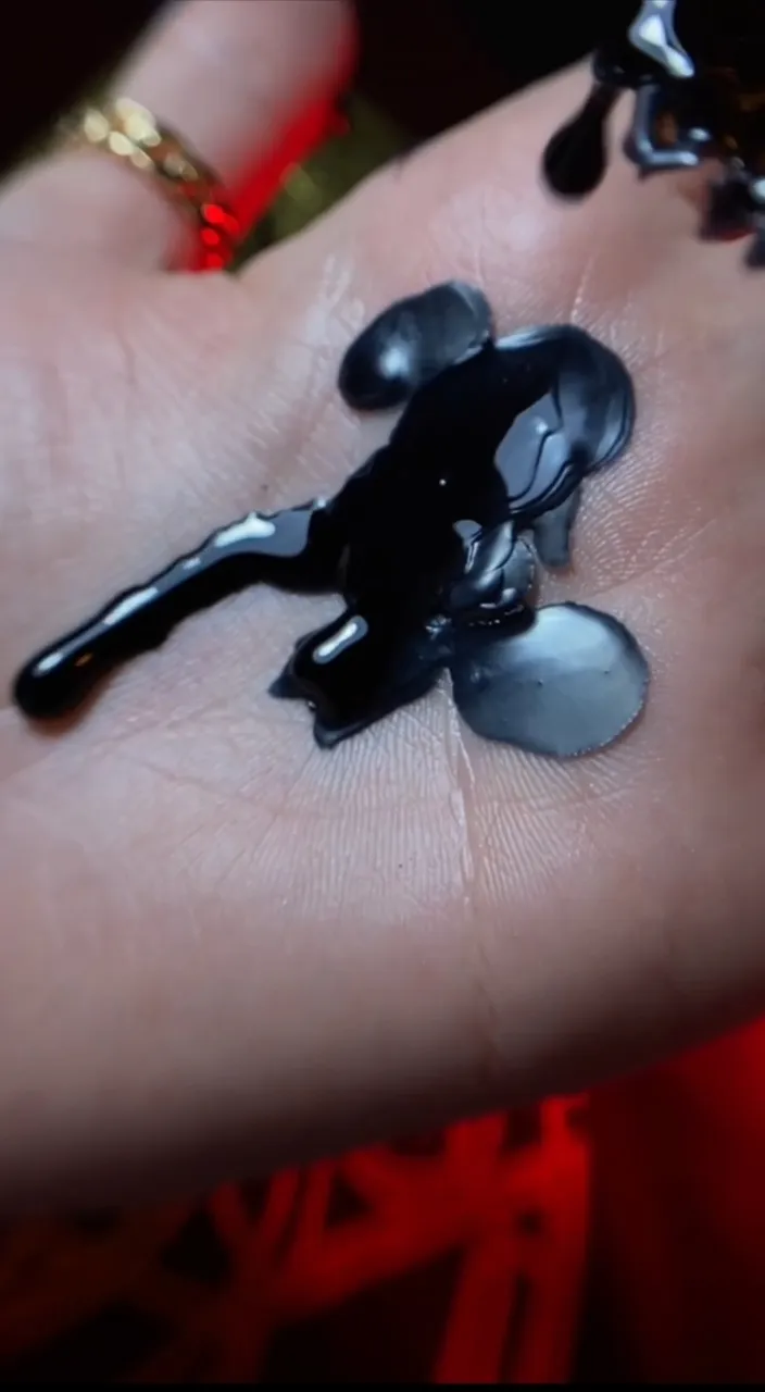 a person's hand with a black substance on it