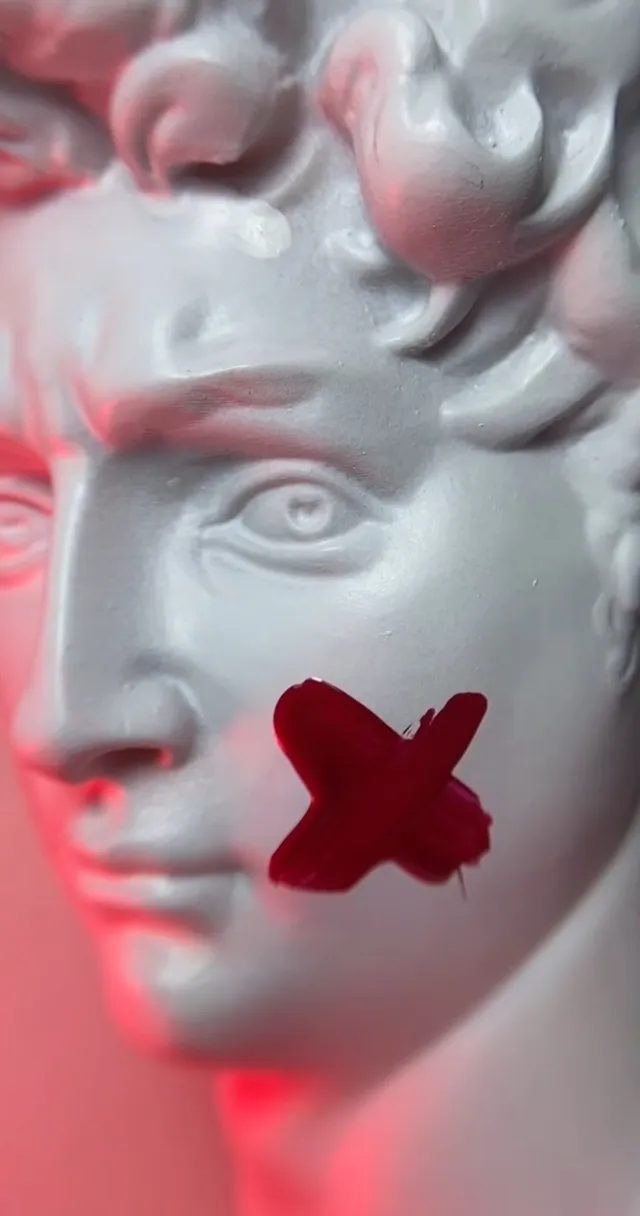 a close up of a statue with a red butterfly on it