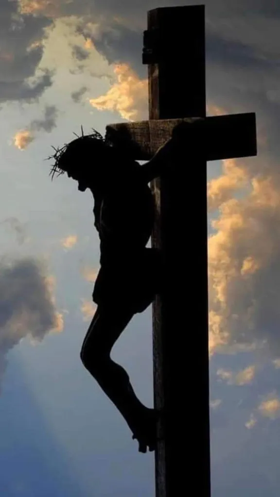 a man climbing up the side of a wooden cross