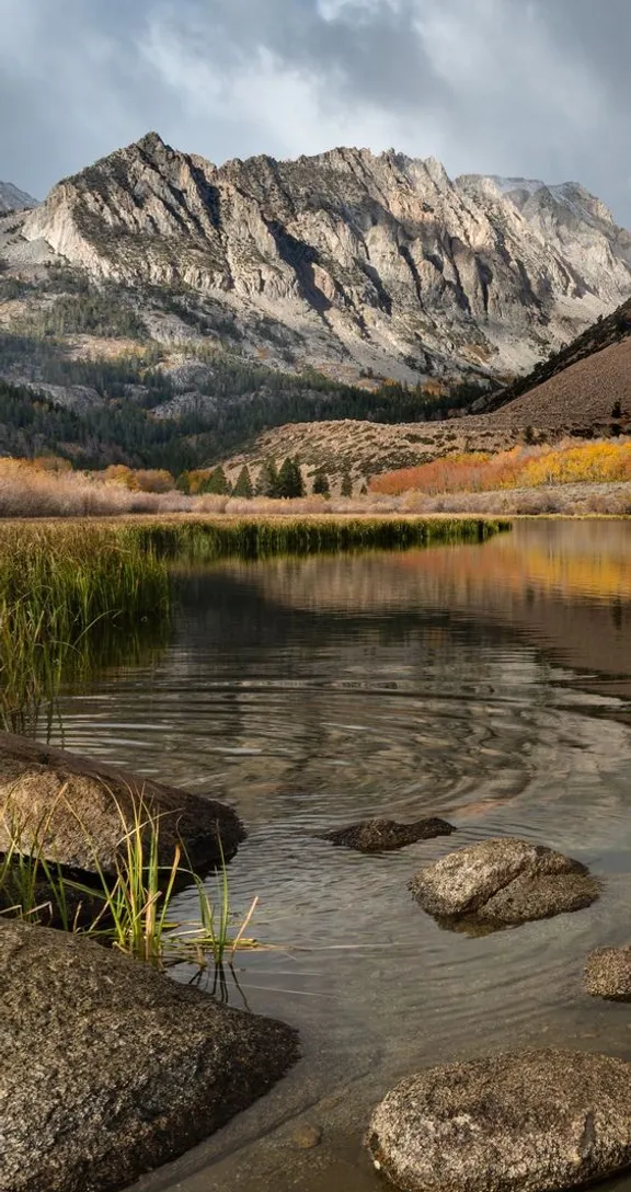 a mountain range with a lake in the foreground