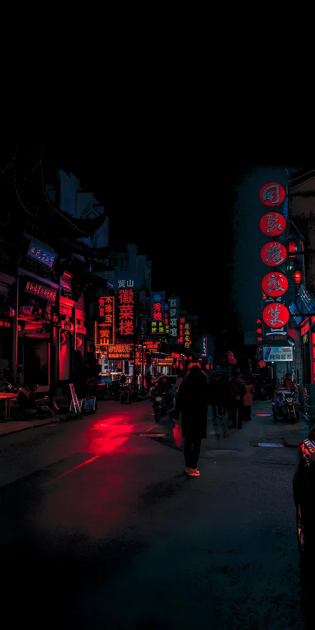 a person walking down a street at night