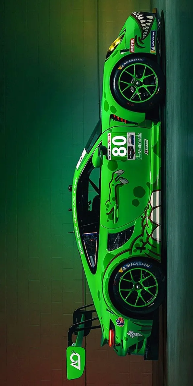 a green race car hanging from the side of a wall