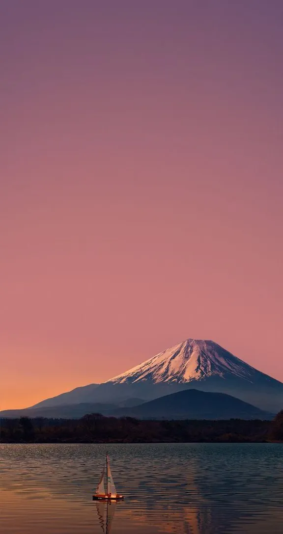 a sailboat on a lake with a mountain in the background