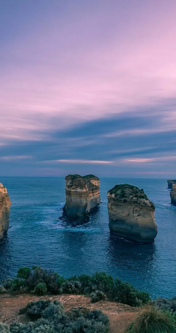 a group of rocks sitting on top of a body of water