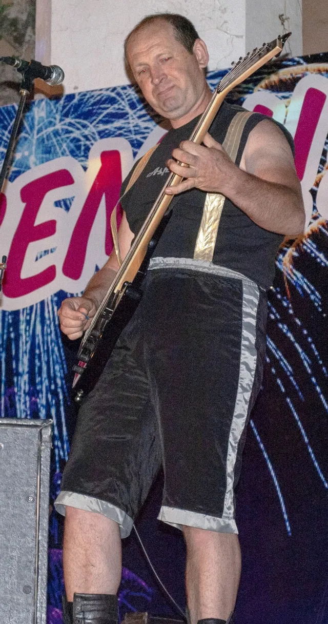 a man standing on a stage with a guitar