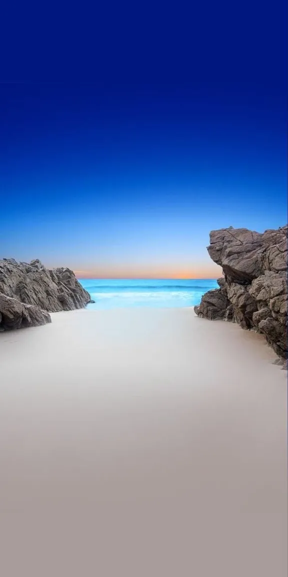 a long exposure photo of a beach at dusk