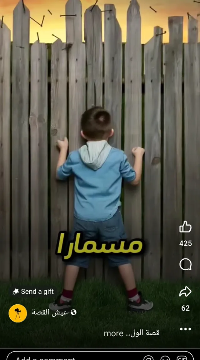 a little boy standing in front of a wooden fence