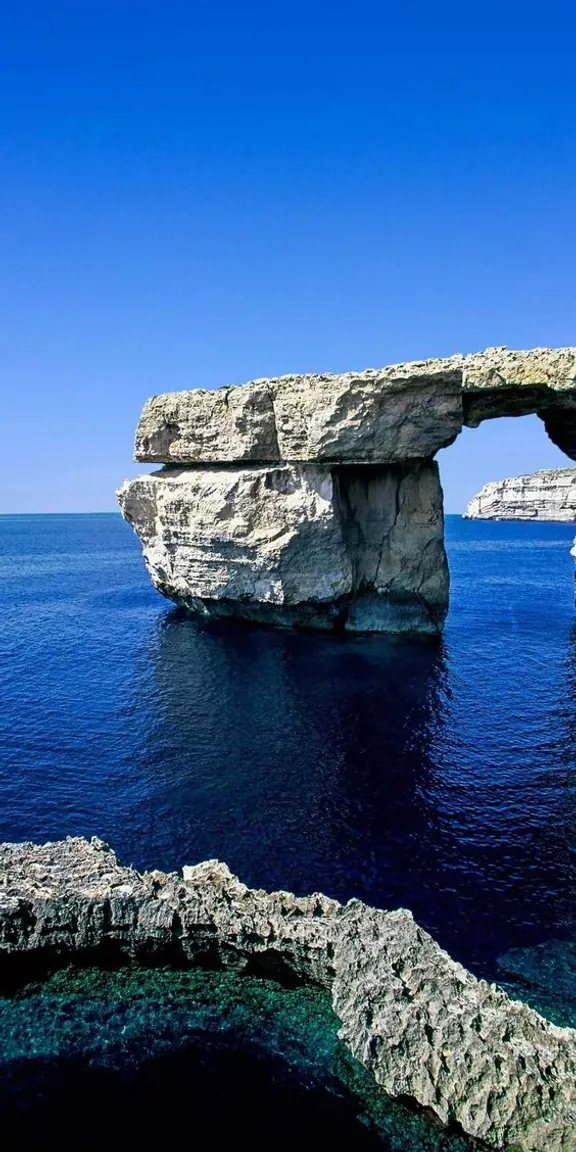 a large rock formation in the middle of the ocean